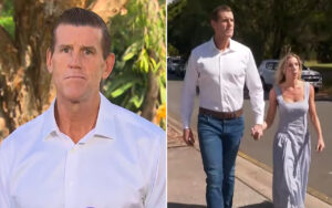 Close-up of a man in a white shirt outdoors, serious expression on a sunny day.