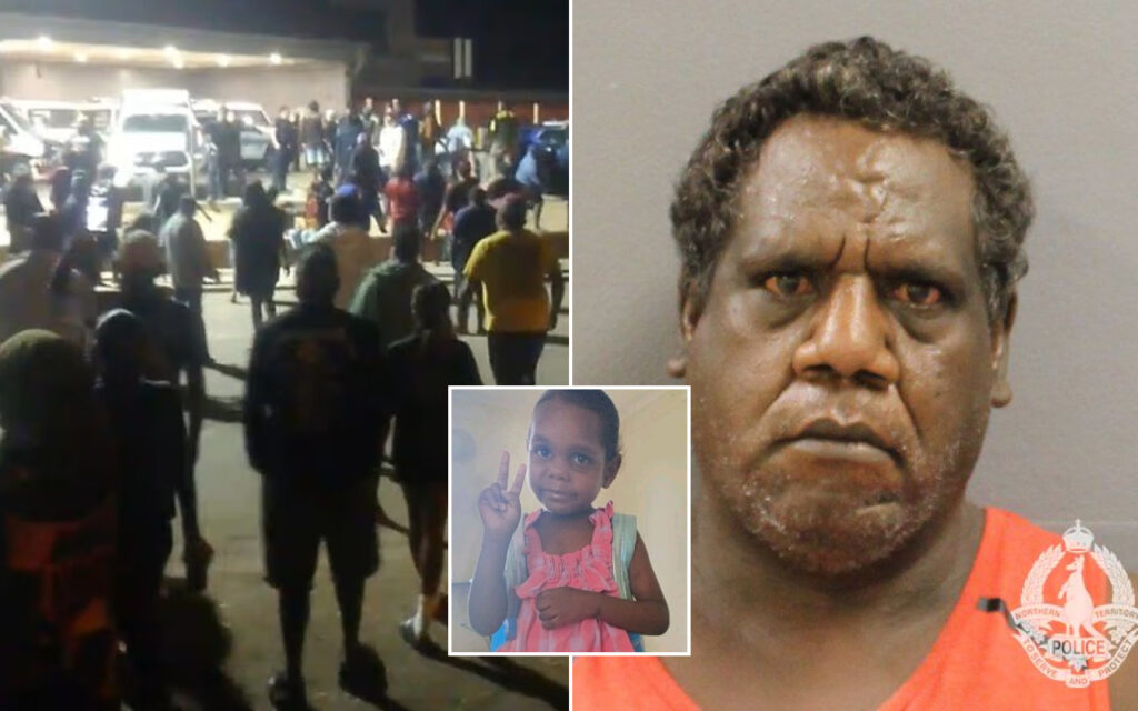 Nighttime crowd outside a building; a serious-looking man in an orange shirt; a young girl in the center making a peace sign.