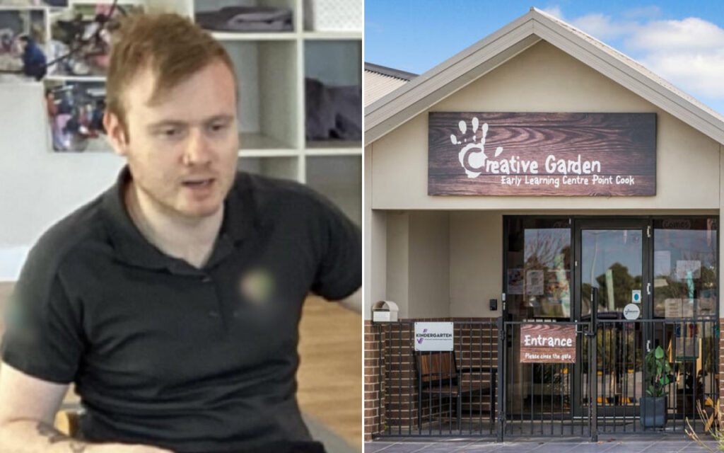 Man in a black polo shirt seated indoors with shelves and photos in the background, talking or presenting.