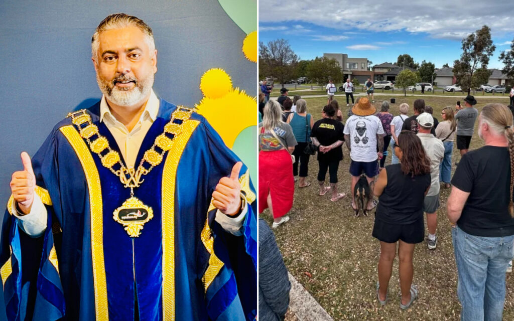 Male official in blue ceremonial gown with gold trim and a large gold chain, giving thumbs up.