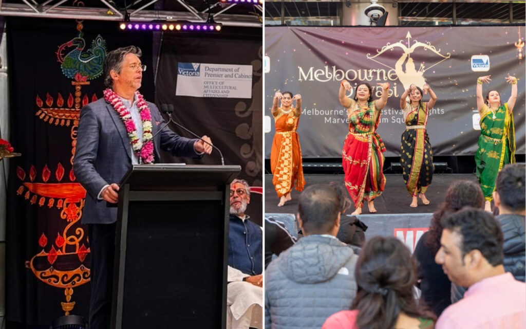 Man speaking at a podium with a garland, on a decorated stage during a multicultural festival.