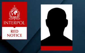 Interpol Red Notice poster with emblem and bold 'RED NOTICE' text, left side; silhouette portrait on white panel with red bar at bottom on the right (face hidden).