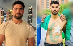Two men posing side by side: left man in beige T-shirt against a city skyline at night; right man shirtless with body paint resembling a flag and a large green scarf draped over his shoulders, standing outdoors.