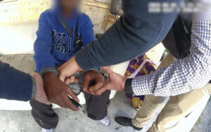 Close-up of several hands stacked together in the center, symbolizing teamwork and collaboration.