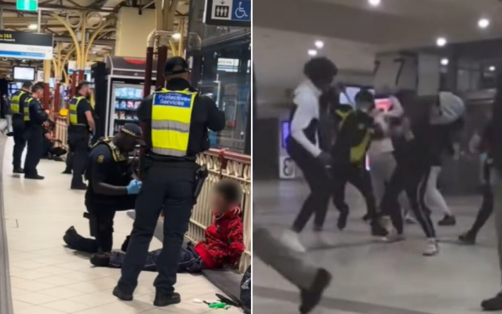 Security officers in high-visibility vests detain a person on the floor at a train station, with a bystander seated nearby in red.