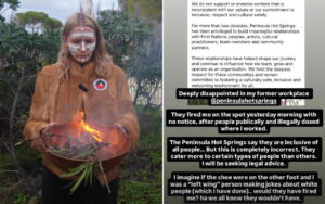 Person with white face paint and a brown fur coat holds a small flame in a bowl of leaves outdoors, with a circular patch on the jacket and plants in the background.