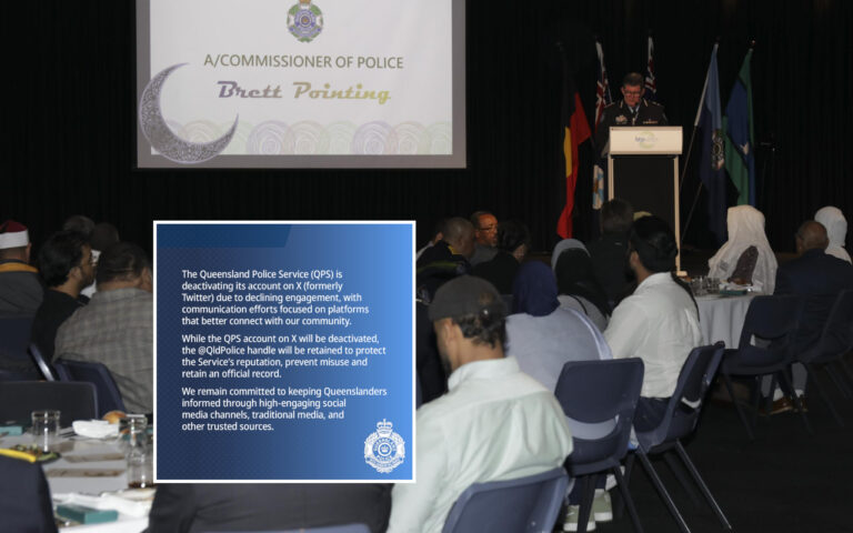 Audience at a police conference; a speaker at a podium with a large screen showing 'A/COMMISSIONER OF POLICE Brett Pointing' and a blue information card in the foreground detailing a Queensland Police Service update on their X account.