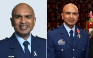 Two portraits of a bald man in a blue military dress uniform: left side against a light backdrop, smiling; right side at a formal event wearing medals and ribbons.