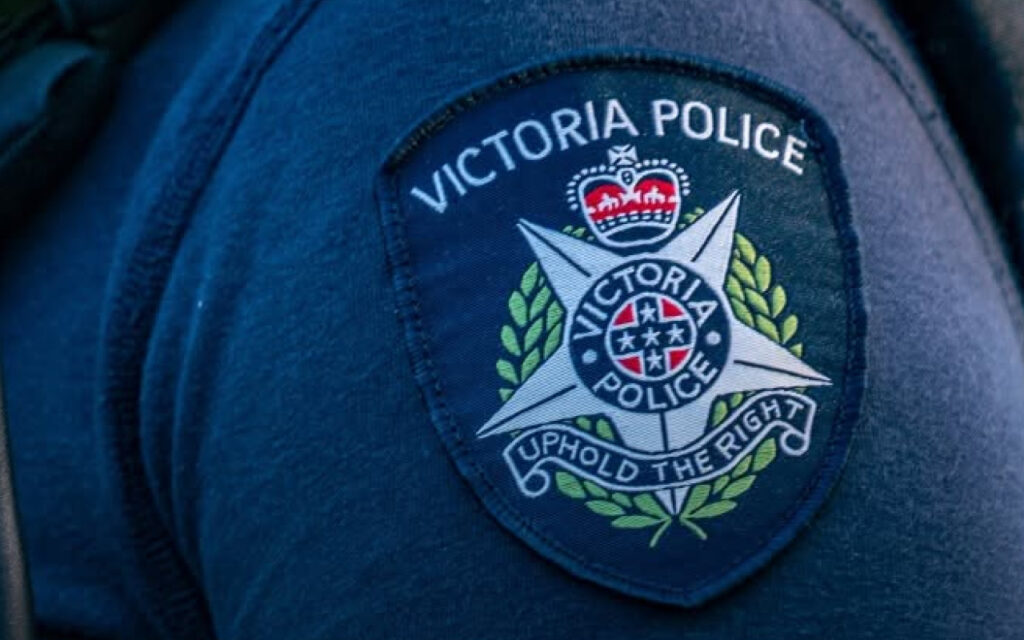 Victoria Police patch on a dark blue uniform showing the crest and 'Uphold the Right' motto.