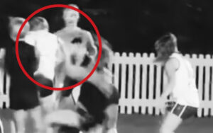 Two people appear to be pushing or shoving each other near a white picket fence, with a red circle highlighting the interaction.