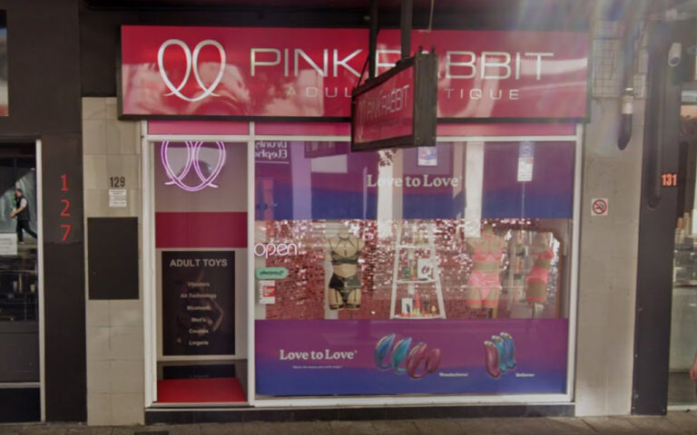 Storefront of an adult toy shop with pink signage and a large window display titled 'Love to Love' showing products (open sign visible).