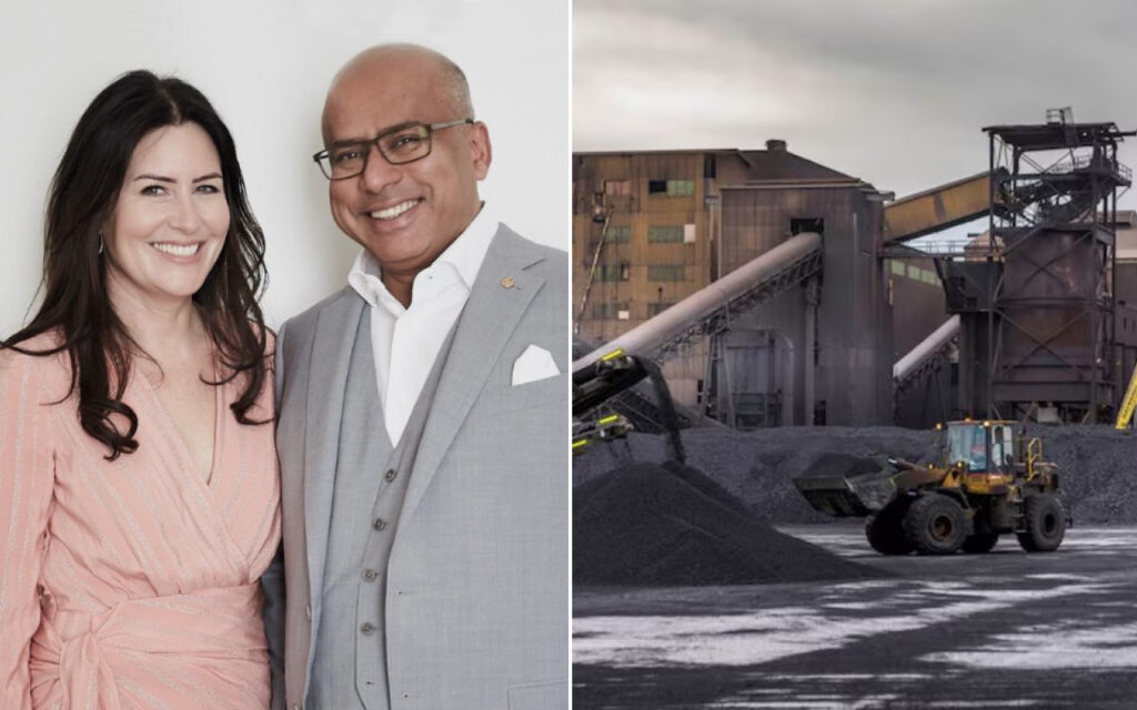 Smiling woman in a pink dress and a man in a gray suit pose together; industrial coal mine with conveyors and a loader behind them.