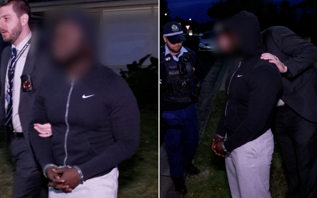 Nighttime, two-panel scene of a man in a black Nike zip hoodie in handcuffs being escorted by a police officer from the left panel to the right panel where a hooded figure rests a hand on his back as another officer looks on.
